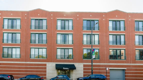Front view of a multi-story brick building with multiple windows.