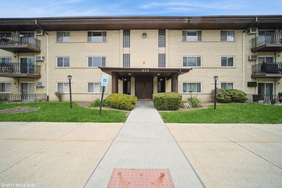 Front view of a multi-story residential building with balconies.