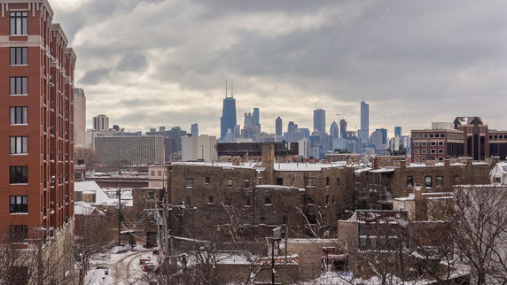 Panoramic view of a cityscape with tall buildings and snowy rooftops.
