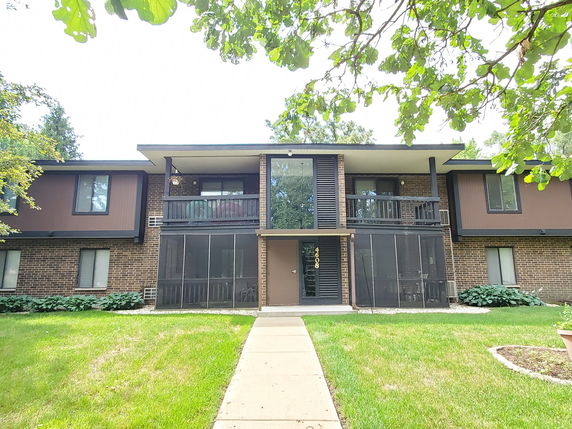 Front view of a two-story apartment building with balconies and brick exterior.