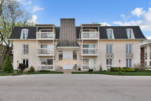 Front view of a multi-story apartment building with balconies.
