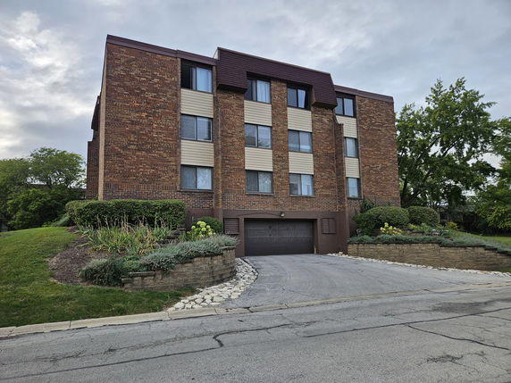 Front view of a multi-story brick building with a garage entrance.