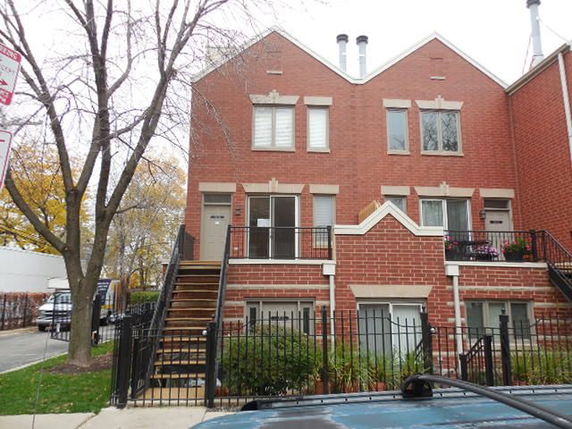 Front view of a two-story brick townhouse with multiple staircases.