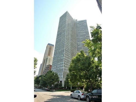 Tall skyscraper building viewed from street level.