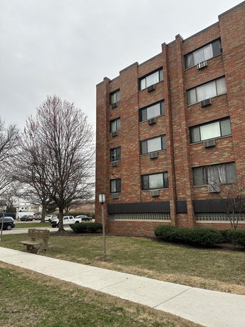 Front view of a multi-story brick apartment building.