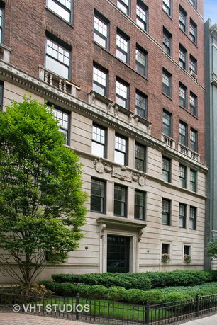 Front view of a multi-story brick building with ornate window details and decorative façade.