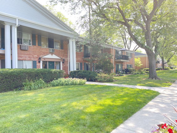 Front view of a two-story building with columns and brick facade.