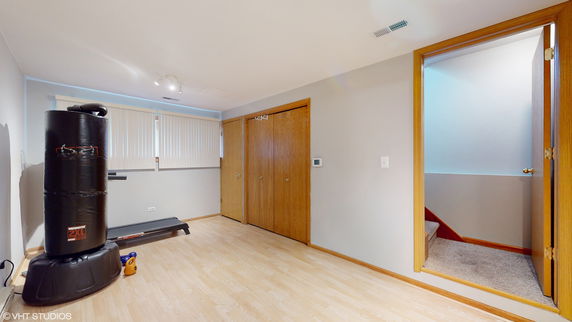 Room with punching bag and treadmill.