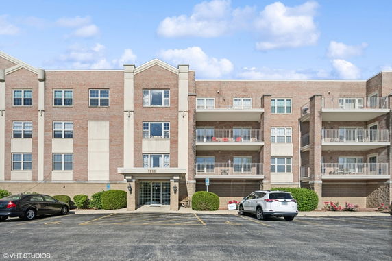 Front view of a multi-story apartment building with balconies.