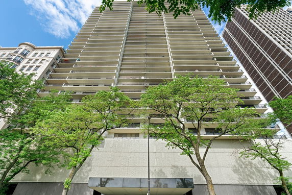 Front view of a high-rise residential building with multiple balconies.