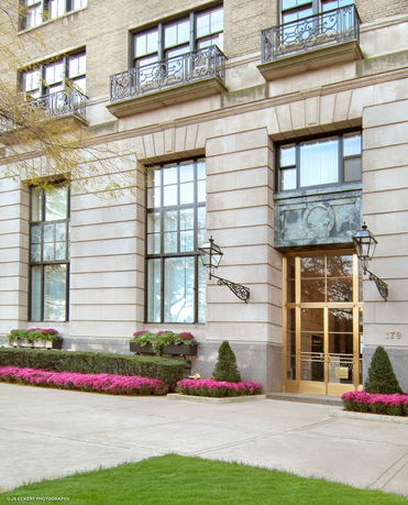 Front view of a multi-story building with decorative balconies and large windows.