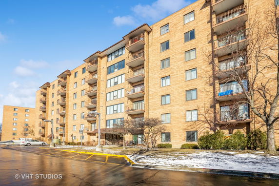 Front view of a multi-story apartment building with balconies.