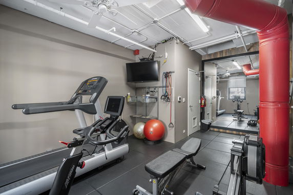 View of an indoor gym with exercise equipment.