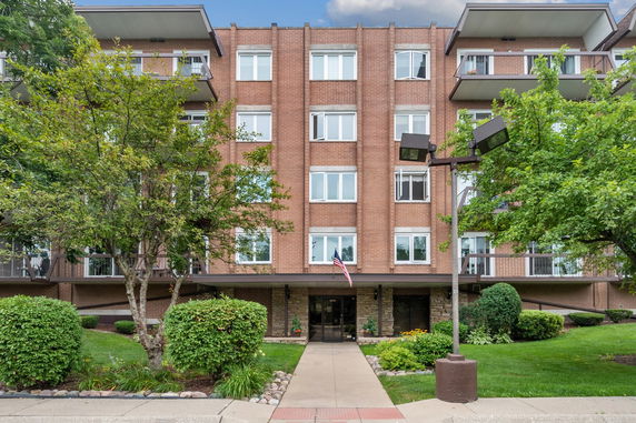 Front view of a multi-story brick building with balconies.