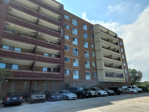 Front view of a multi-story apartment building with balconies.