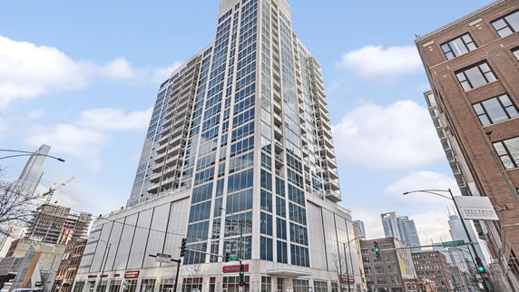 Front view of a modern high-rise building with extensive glass windows and balconies.