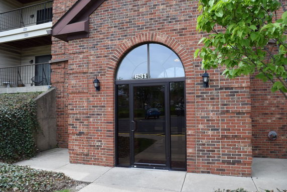 Front view of a brick building with an arched doorway and the number 631 above the entrance.