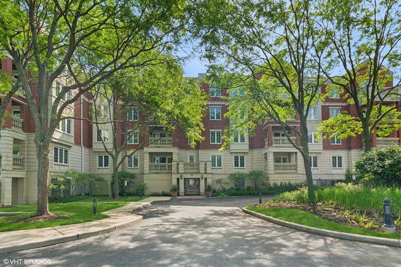 Front view of a multi-story brick building with balconies and a formal entrance.