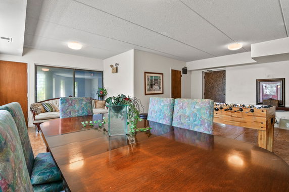 Interior of a recreation room with table and foosball game.