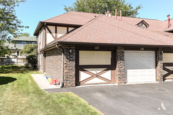 Front view of a two-story house with a brick facade and dual garages.