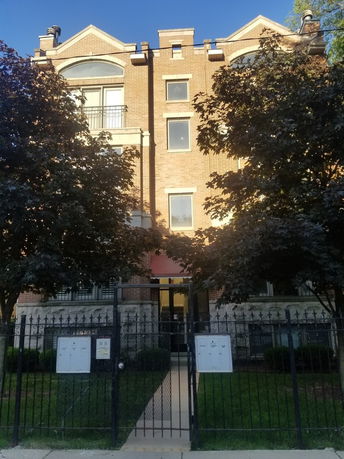 Front view of a multi-story brick building with arched windows.