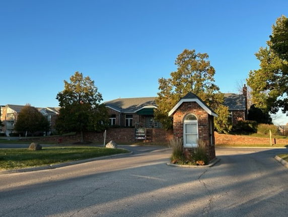 Front view of a building with a small entrance hut and trees around it.