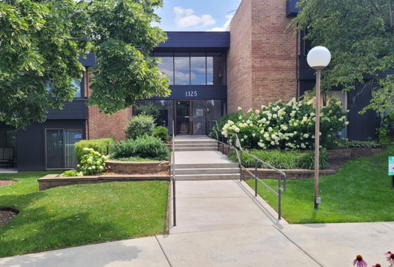 Front view of a multi-story building with brick and glass facade.