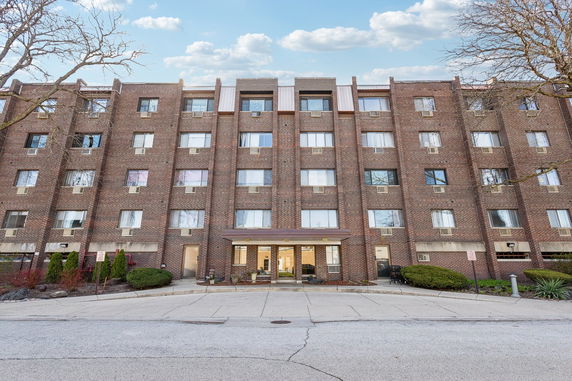 Front view of a multi-story brick apartment building.