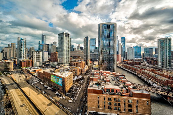 Panoramic view of a city skyline with tall buildings and a river.