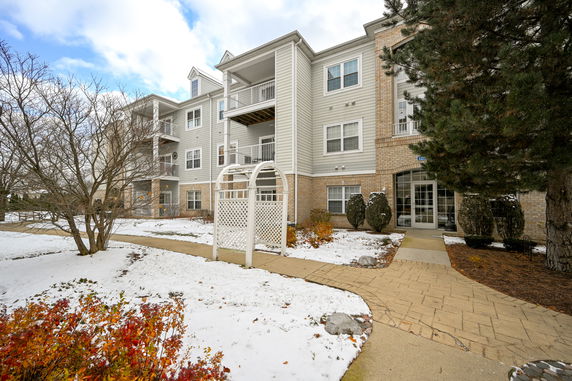 Front view of a multi-story apartment building with balconies and a main entrance.