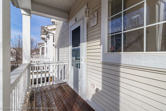 View from a porch of a house overlooking neighboring houses and trees.