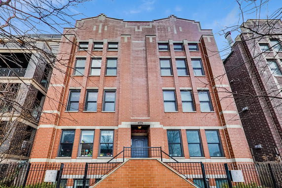Front view of a multi-story brick building with multiple windows.