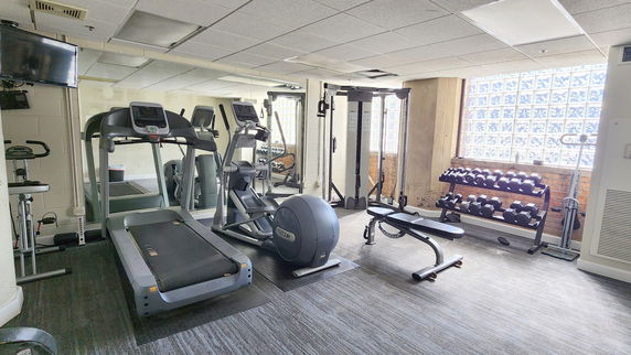 Indoor gym area with exercise equipment and dumbbells.