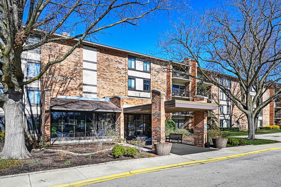 Front view of a multi-story brick building with balconies.