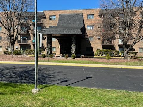 Front view of a multi-story brick building with a covered entrance.