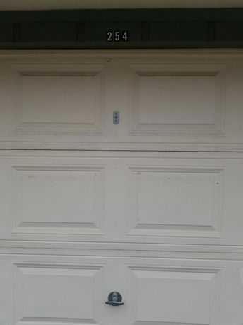 Front view of a garage door with the number 254 above it.