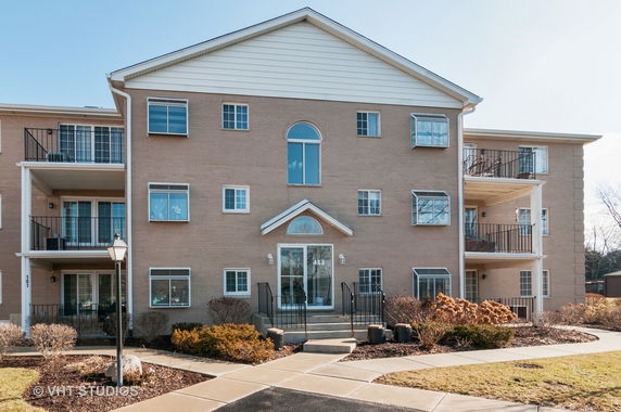Front view of a multi-story apartment building with balconies.