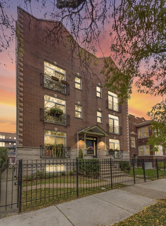 Front view of a multi-story brick building with balconies.