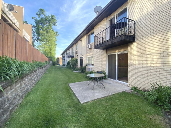 Front view of a two-story building with balconies and sliding glass doors.