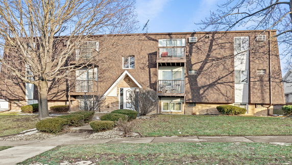 Front view of a multi-story apartment building with balconies.