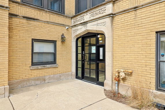 Front view of a building with a glass entrance and brick facade.