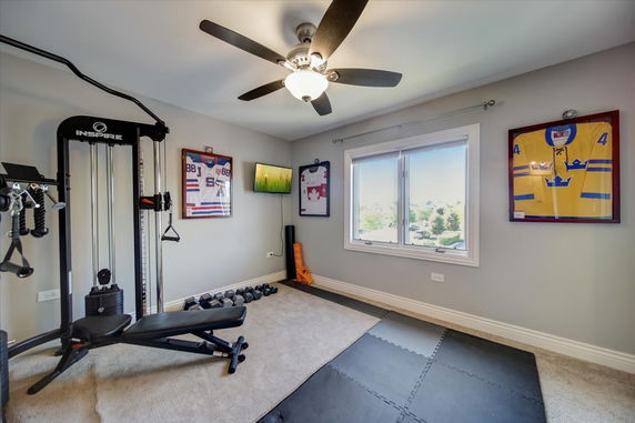 Indoor gym area with exercise equipment and sports memorabilia.