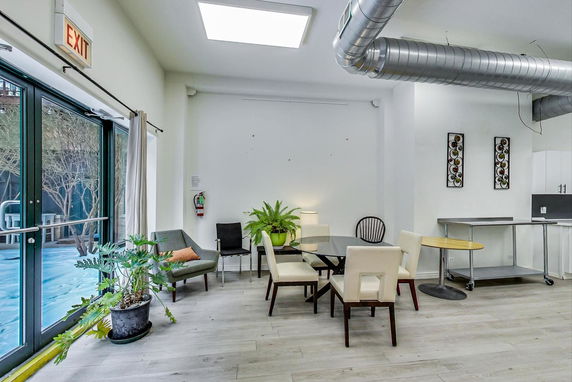 Interior of a modern clubhouse with seating and decorative plants.