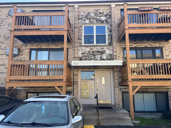 Front view of a multi-story building with balconies and a central entrance.