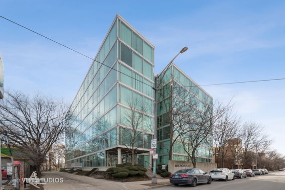 Front view of a modern multi-story glass building.