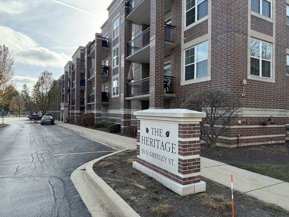 Front view of a multi-story brick apartment building labeled 'The Heritage' with balconies.