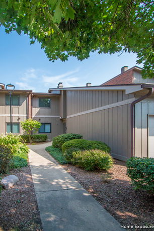 Front view of a two-story residential building with brown paneling.