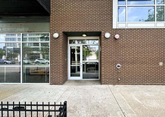 Front view of a building with a glass door and brick exterior.