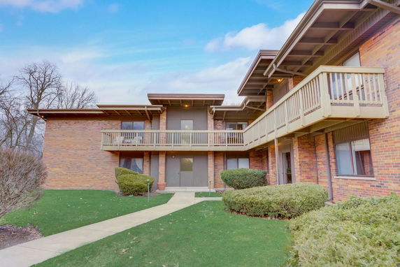 Front view of a two-story building with balconies and brick exterior.