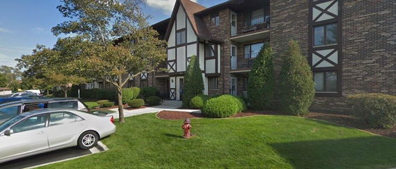 Front view of a multi-story residential building with brick and timber facade.